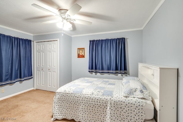 bedroom with ornamental molding, light colored carpet, ceiling fan, and a closet