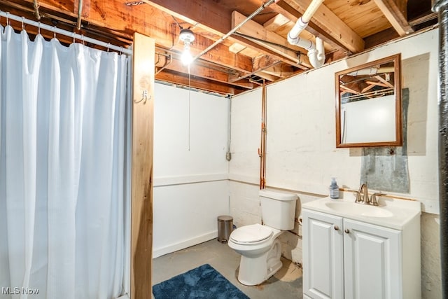 bathroom with vanity, concrete flooring, toilet, and a shower with shower curtain