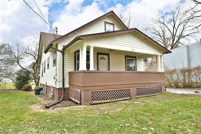 bungalow featuring a front lawn, central air condition unit, and covered porch