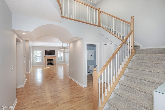 staircase with hardwood / wood-style flooring and a towering ceiling