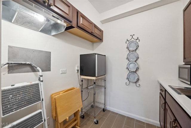 kitchen with range hood and dark brown cabinets