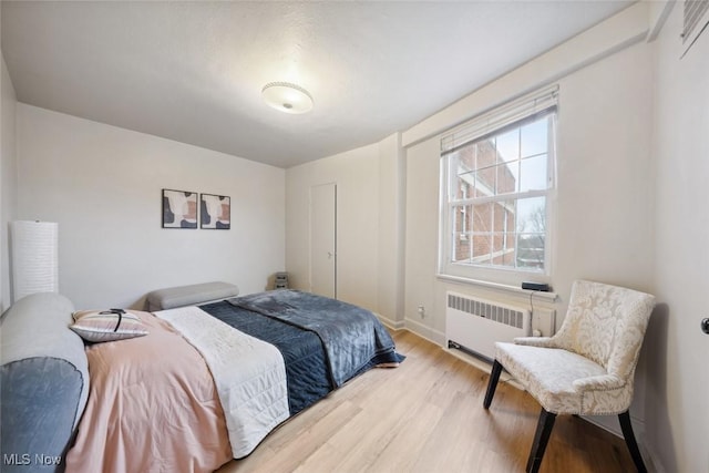 bedroom featuring radiator and light wood-type flooring