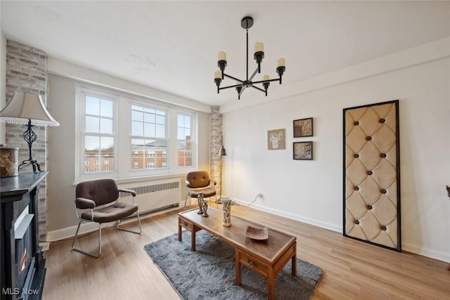 sitting room with an inviting chandelier, radiator heating unit, and light hardwood / wood-style floors