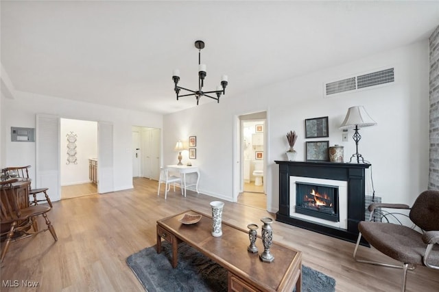 living room with a chandelier and light wood-type flooring