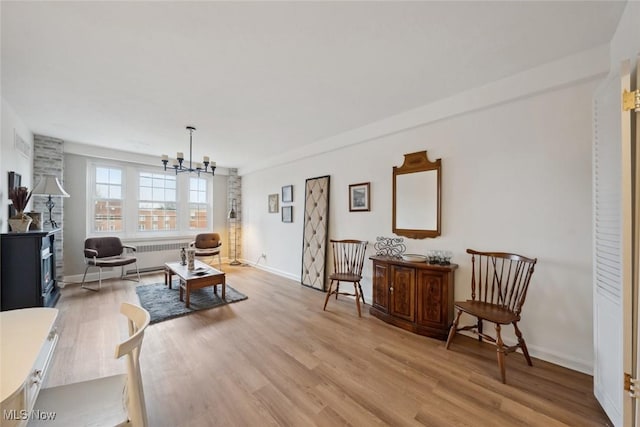 living room featuring an inviting chandelier, radiator heating unit, and light hardwood / wood-style flooring