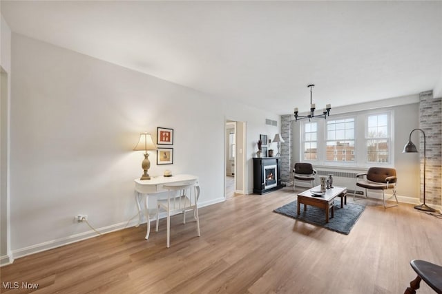 living room featuring a chandelier, radiator, and light hardwood / wood-style floors