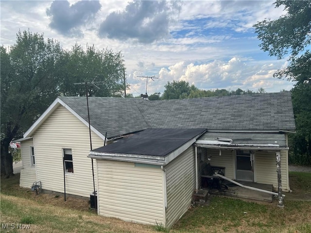 back of house with cooling unit and a yard