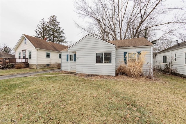 rear view of property with a lawn and a deck