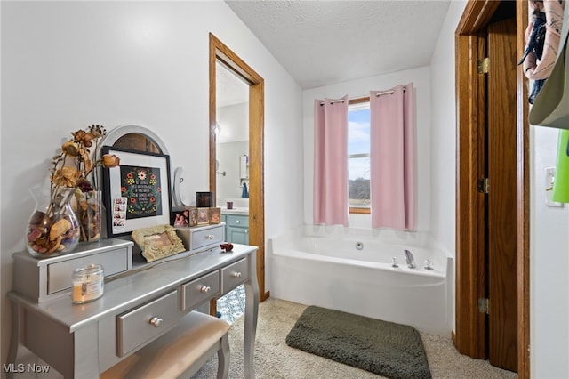 full bathroom with vanity, a textured ceiling, and a bath