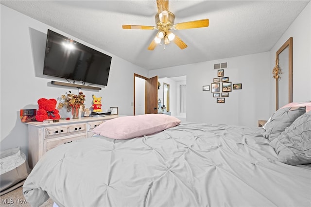 bedroom with ceiling fan, visible vents, and a textured ceiling