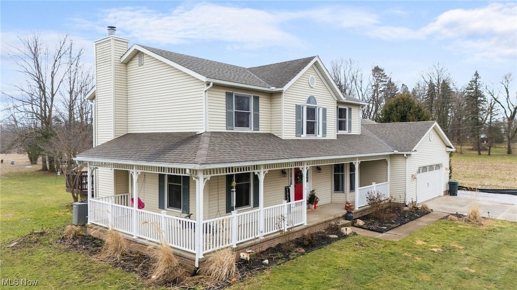 farmhouse inspired home with a front yard, covered porch, roof with shingles, and concrete driveway