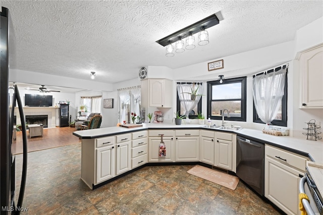 kitchen with a peninsula, a sink, white cabinets, light countertops, and dishwasher