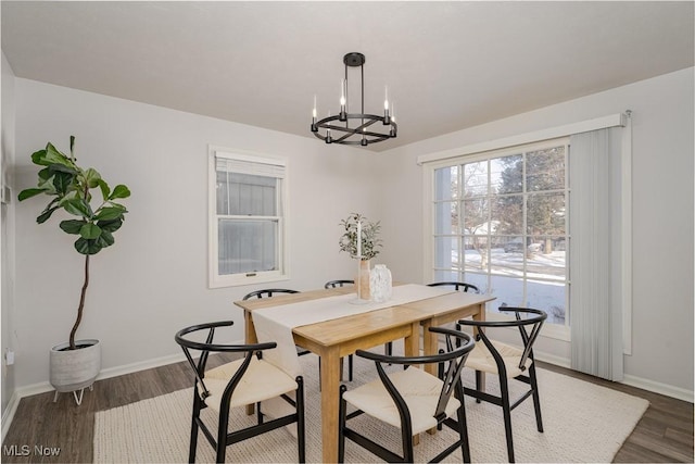 dining area with an inviting chandelier and dark wood-type flooring