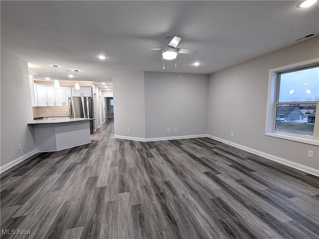 unfurnished living room with dark wood-type flooring and ceiling fan