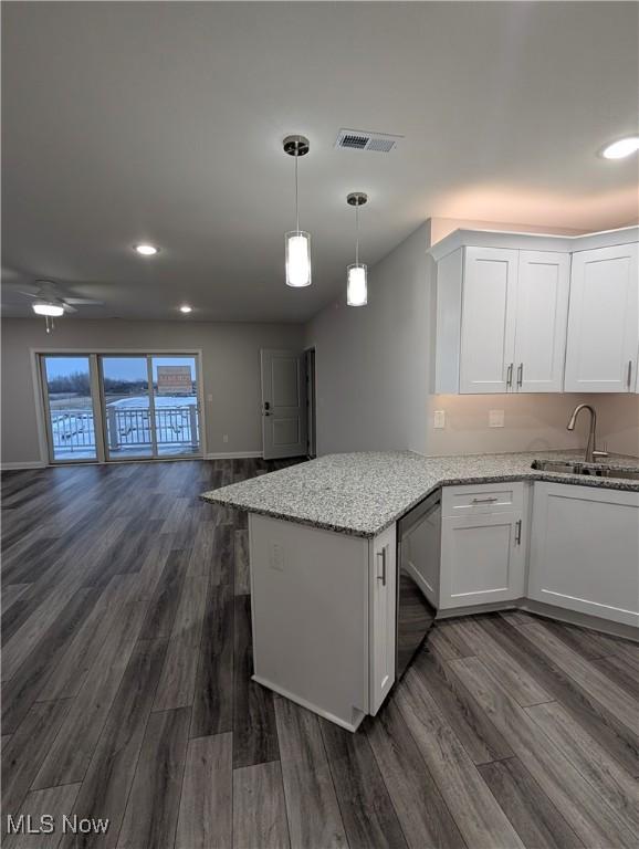 kitchen featuring sink, white cabinetry, dark hardwood / wood-style flooring, black dishwasher, and kitchen peninsula