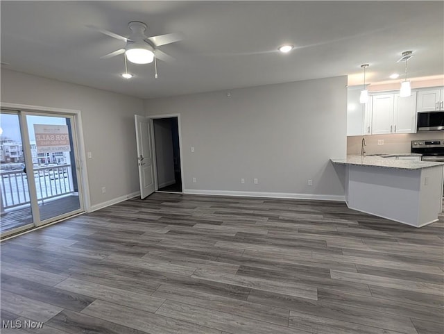 kitchen featuring sink, dark hardwood / wood-style floors, stainless steel appliances, light stone countertops, and white cabinets