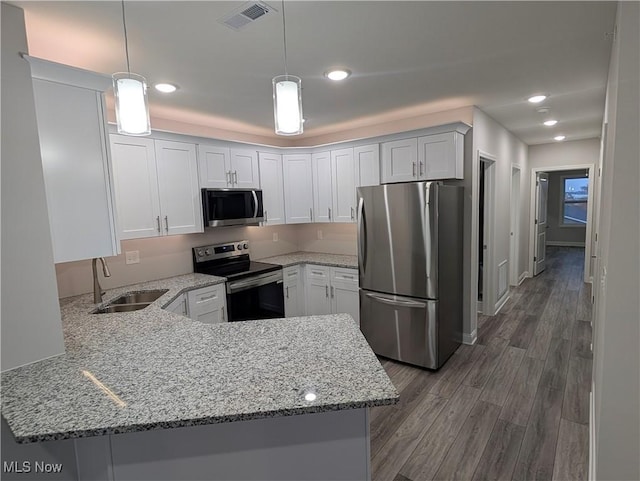 kitchen with sink, kitchen peninsula, and appliances with stainless steel finishes