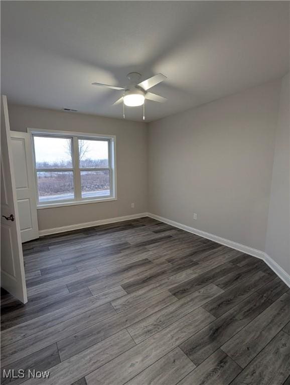 spare room featuring ceiling fan and dark hardwood / wood-style flooring