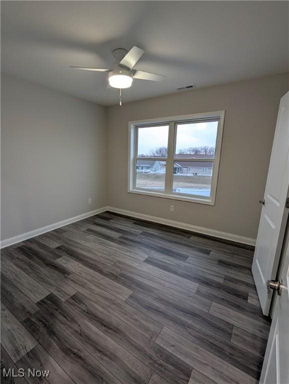 spare room with dark hardwood / wood-style floors and ceiling fan