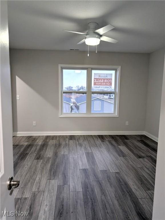 empty room with dark hardwood / wood-style floors and ceiling fan