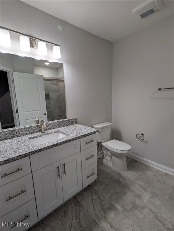 bathroom featuring an enclosed shower, vanity, and toilet