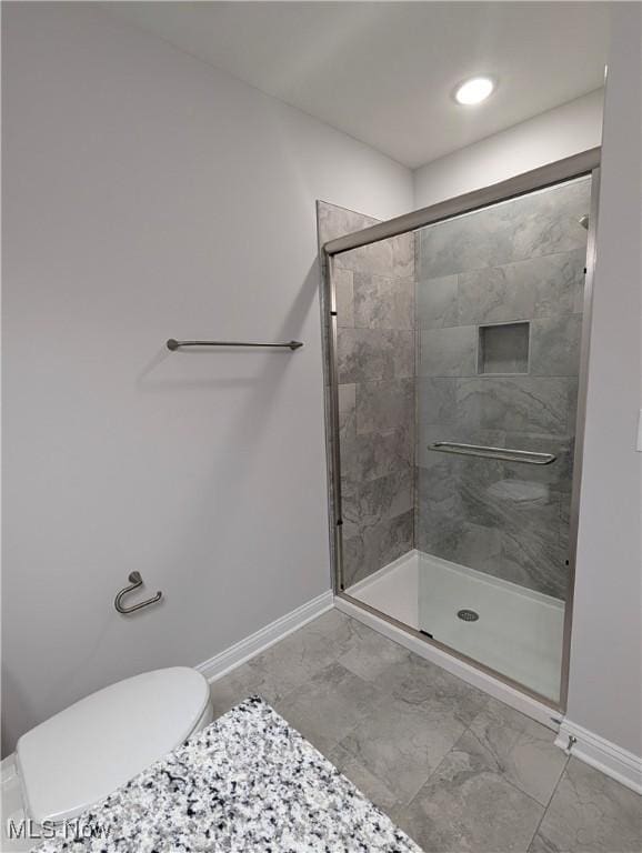 bathroom featuring toilet and an enclosed shower