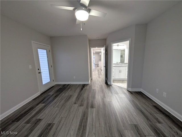 empty room with dark wood-type flooring, sink, and ceiling fan