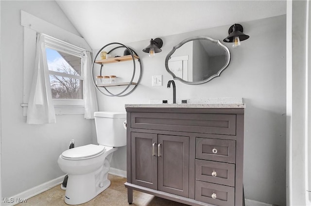 bathroom featuring vanity, lofted ceiling, and toilet