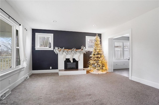 unfurnished living room with plenty of natural light and carpet