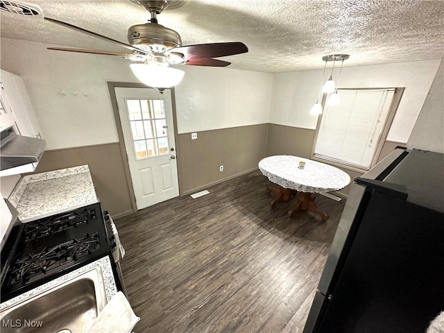 unfurnished dining area with ceiling fan, dark hardwood / wood-style floors, and a textured ceiling