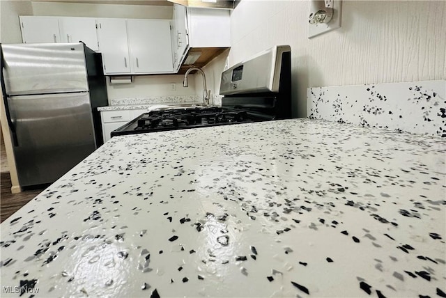 kitchen with white cabinetry and stainless steel refrigerator