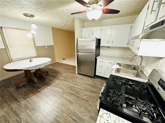 kitchen with white cabinetry, stainless steel appliances, sink, and hanging light fixtures