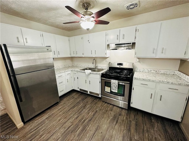 kitchen featuring sink, white cabinetry, stainless steel appliances, a textured ceiling, and dark hardwood / wood-style flooring