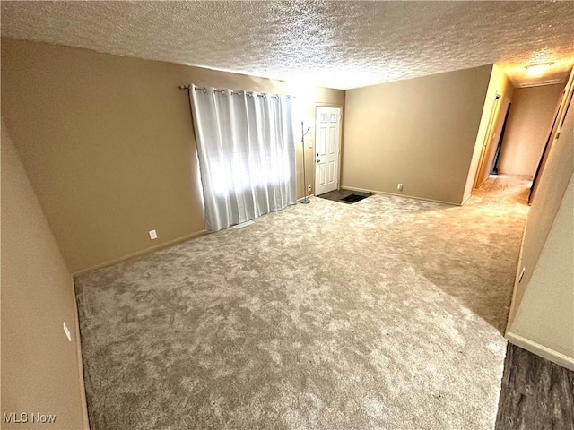 empty room with carpet flooring and a textured ceiling