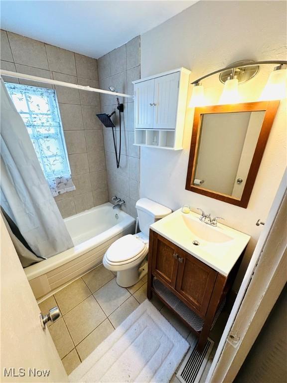 full bathroom featuring vanity, tile patterned flooring, toilet, and shower / bath combo