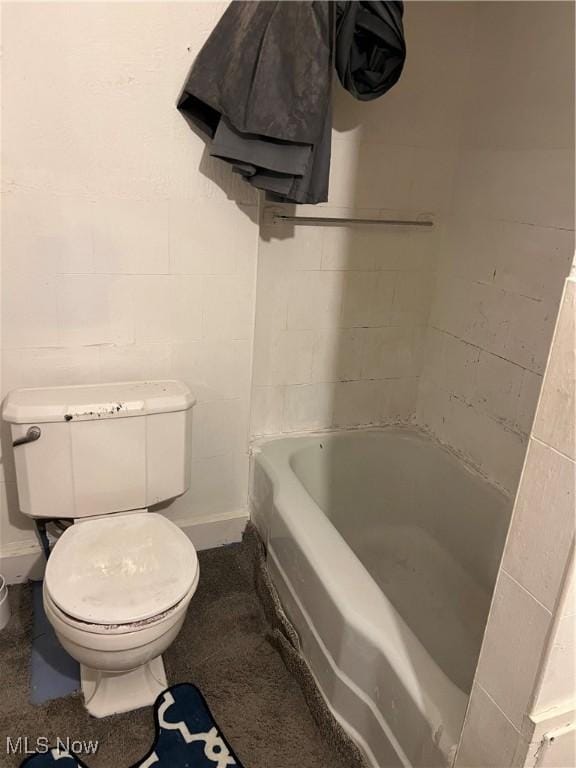 bathroom featuring a tub to relax in and toilet