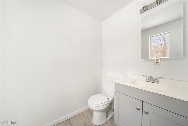 bathroom featuring vanity, wood-type flooring, and toilet