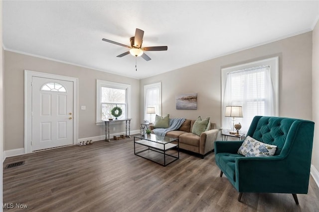 living room with ornamental molding, dark hardwood / wood-style floors, and ceiling fan