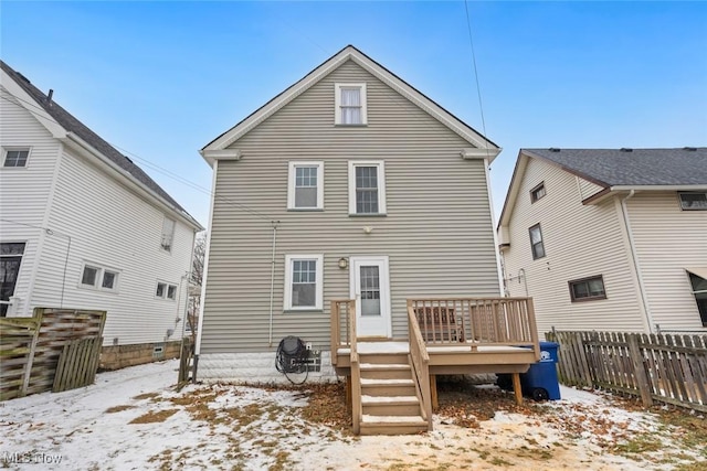 snow covered house featuring a deck