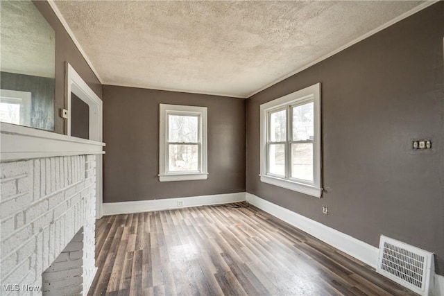 unfurnished living room with hardwood / wood-style flooring, crown molding, and a textured ceiling