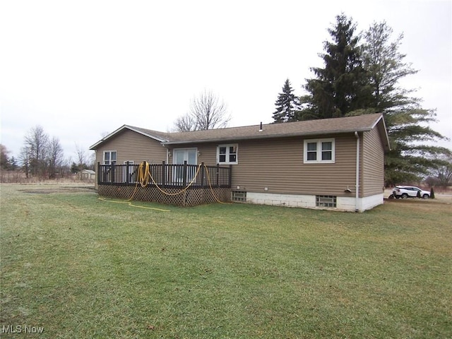 back of property featuring a deck and a lawn