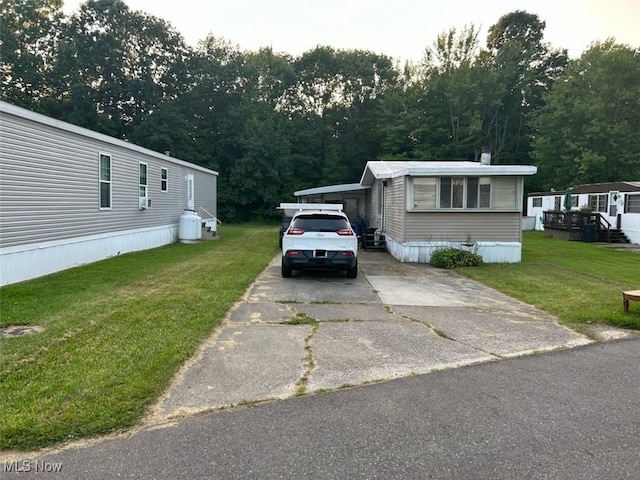 view of front of home with a front yard and a carport