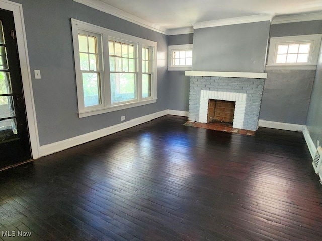 unfurnished living room with a brick fireplace, crown molding, dark hardwood / wood-style floors, and a healthy amount of sunlight