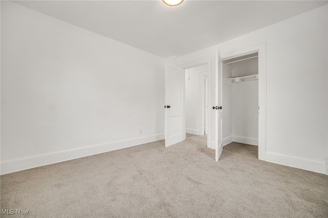 unfurnished bedroom featuring a closet and light carpet