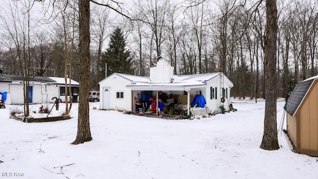 view of snow covered rear of property