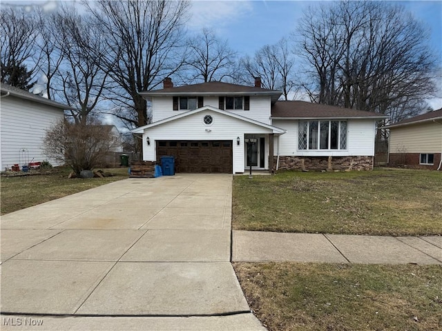 split level home featuring driveway, stone siding, a chimney, an attached garage, and a front lawn