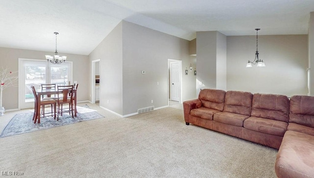 carpeted living room featuring an inviting chandelier and high vaulted ceiling