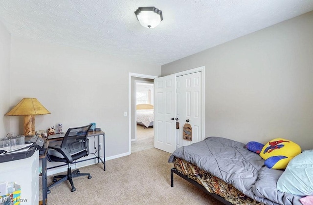 bedroom featuring light colored carpet, a textured ceiling, and a closet