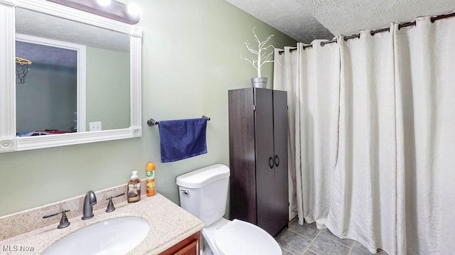 bathroom featuring vanity, a textured ceiling, and toilet