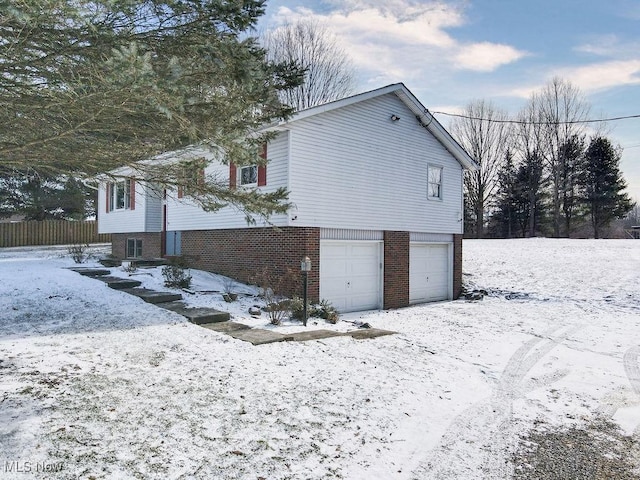 view of snowy exterior with a garage